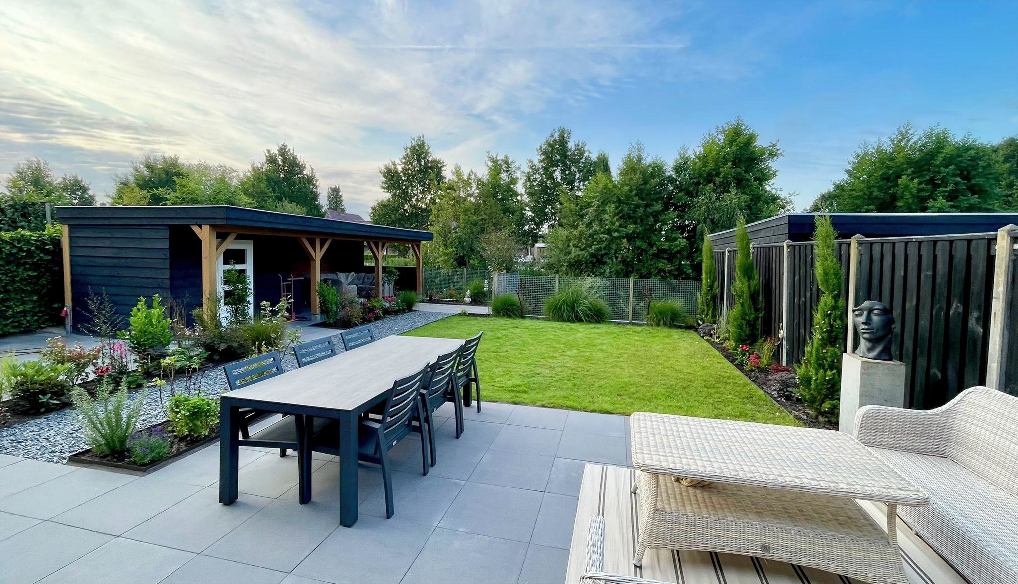 Prachtige aangelegde tuin met terras, gazon en tuinhuis